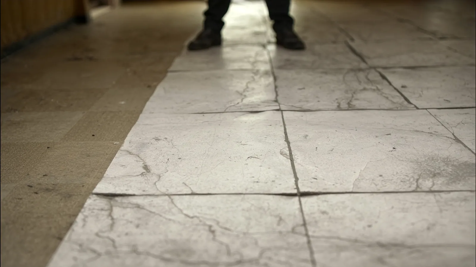 Damaged vinyl sheet flooring in a Seattle Capitol Hill home before replacement — lifting edges and worn finish